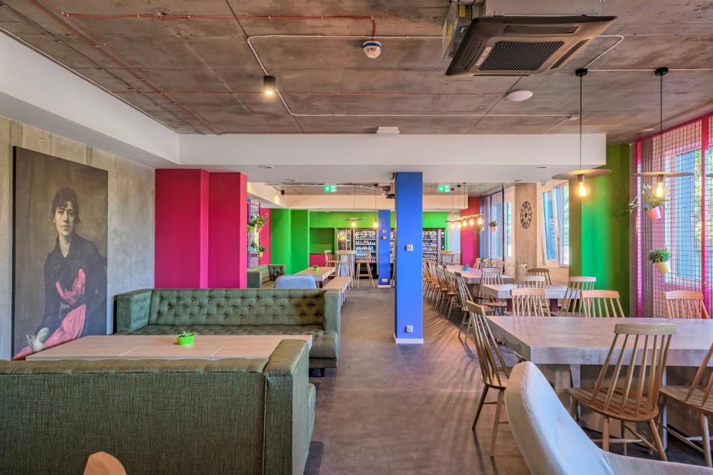 克拉科夫Easy One Premium Art Hostel的餐厅设有桌椅和色彩缤纷的墙壁