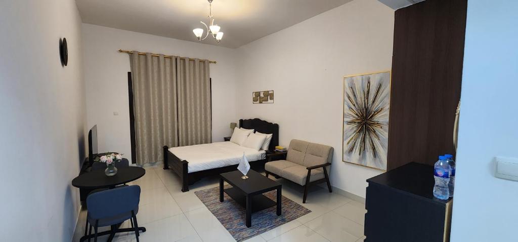 迪拜Elite 6 Sports Residence by Golden Casa的配有一张床和一把椅子的酒店客房