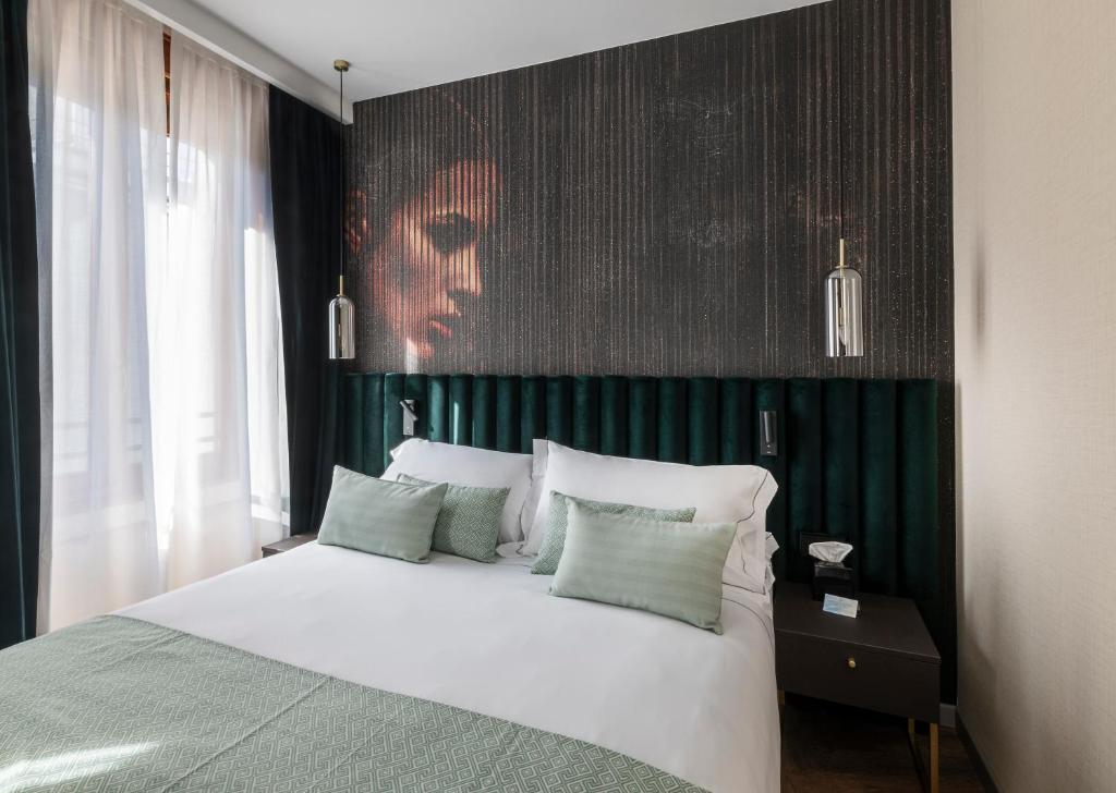 米兰Duomo Hotel & Apartments的一间卧室配有一张白色的床和绿色的墙壁