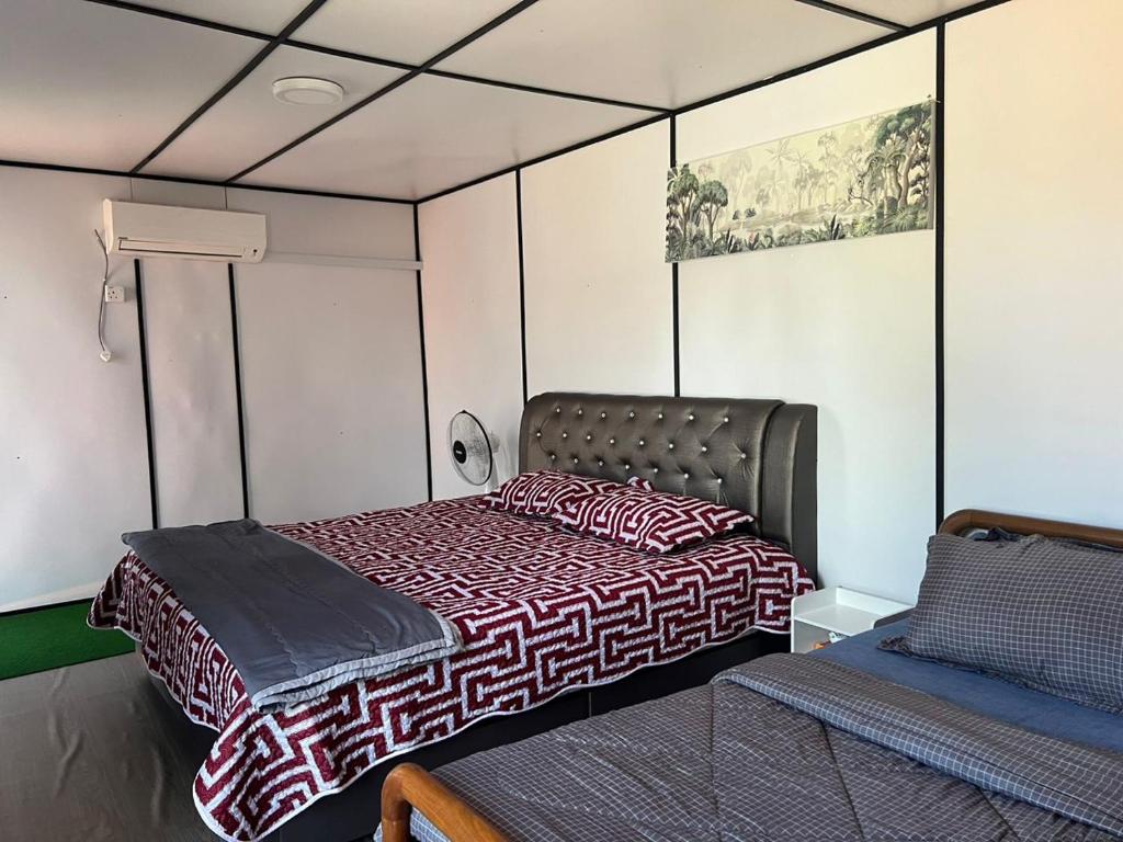 瓜拉丁加奴Rimbun Bayu Homestay的一间带一张床铺的卧室,位于一个带沙发的房间