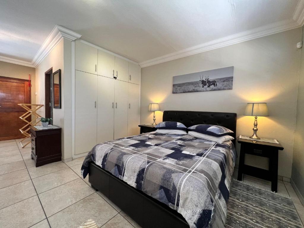鲸湾港Nomland的一间卧室配有一张床和两张台灯。