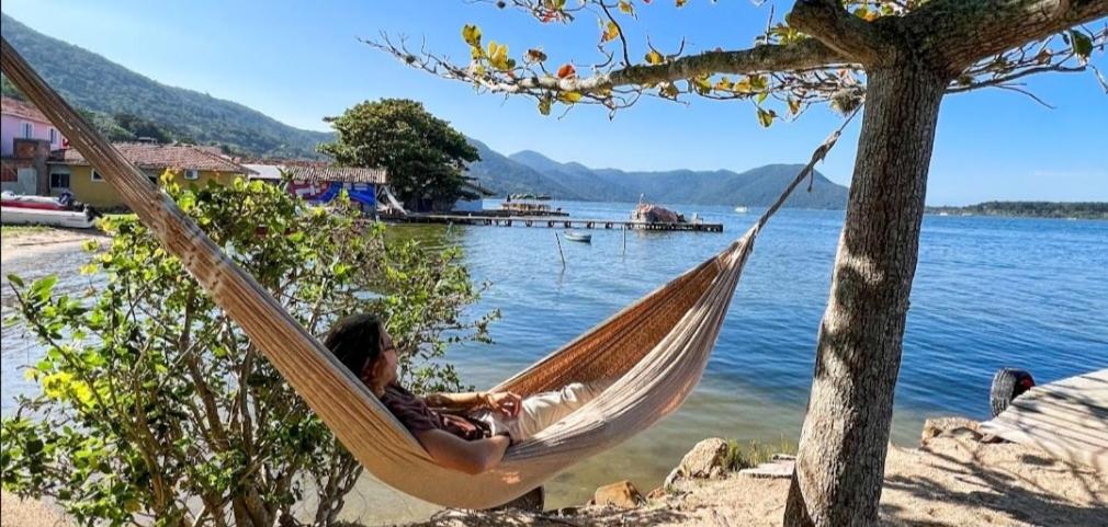 弗洛里亚诺波利斯Refugio Bela Ilha via Barco的躺在湖边吊床上的男人
