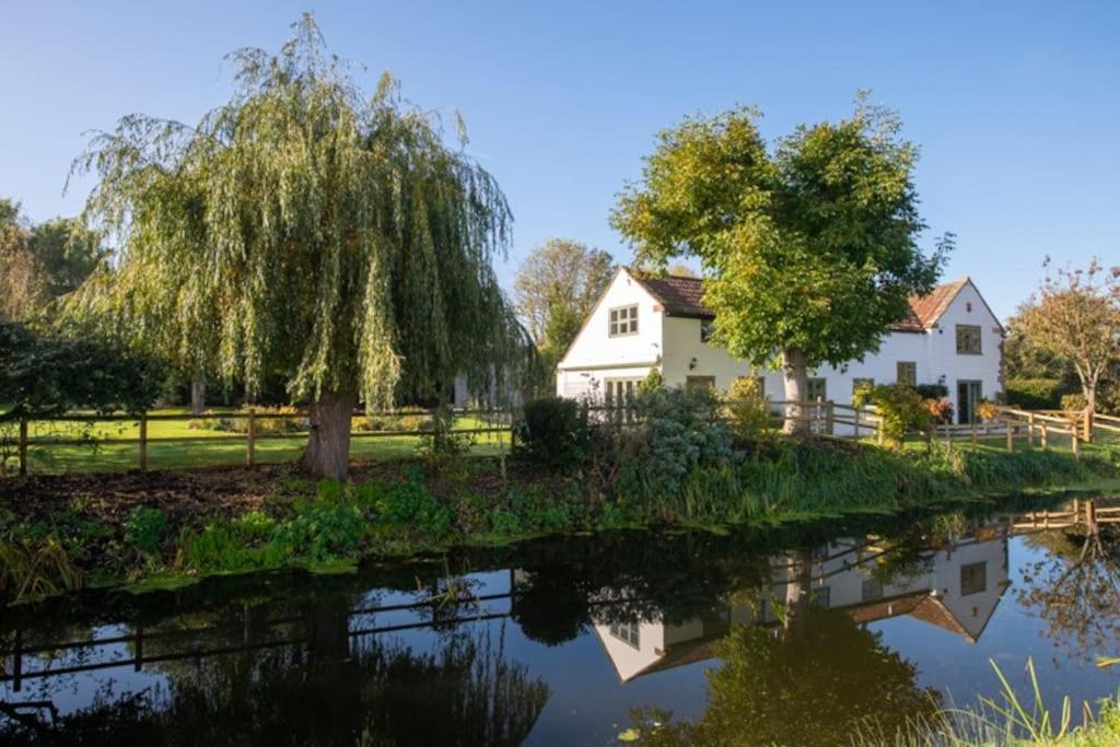 兰波特Peaceful Riverside Five Bed Cottage in Somerset的河边的房屋和树木