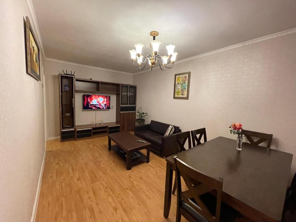 乌兰巴托Two-Bedroom Apartment的客厅配有桌子、沙发和电视