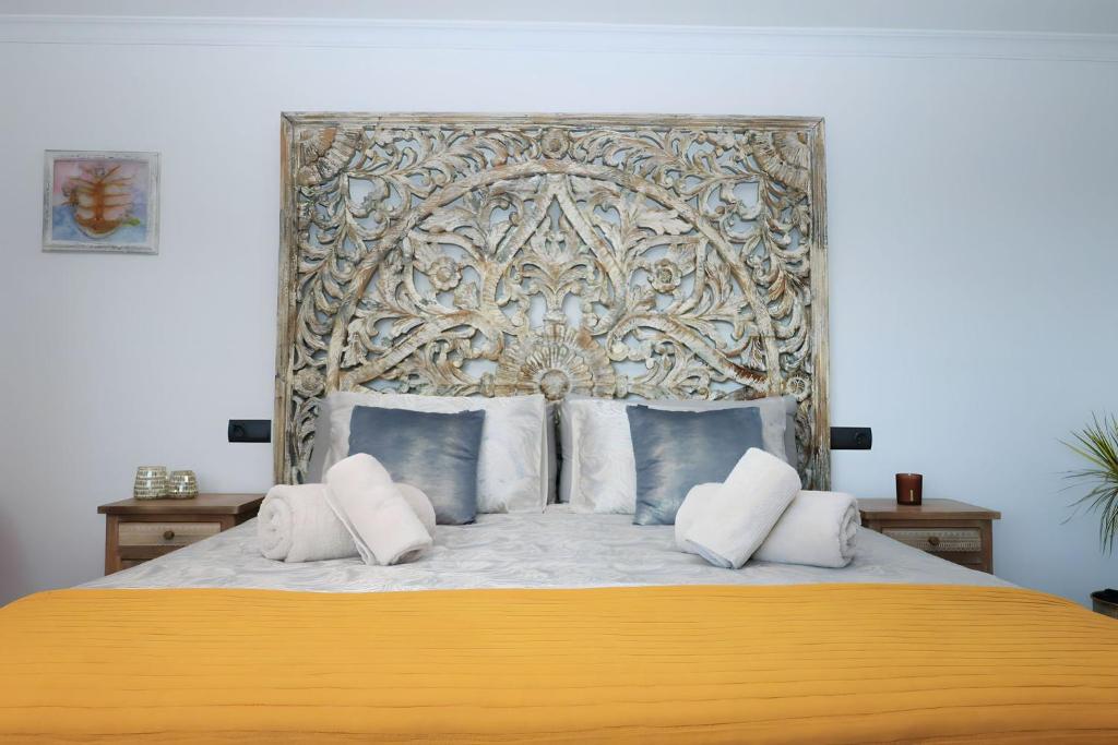 EsteponaLa Pina Verde的一间卧室配有一张大床和金色床头板