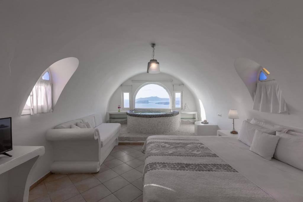 梅加洛克里卡尔德拉私人景观别墅的白色的客厅设有一张大床和一个浴缸。