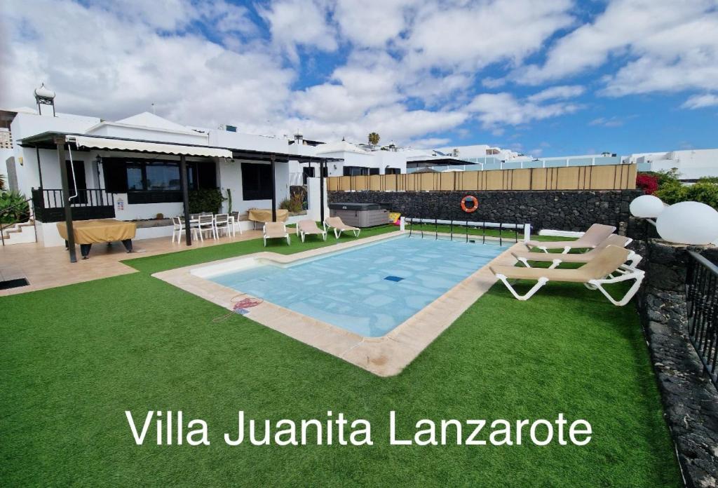 蒂亚斯Villa Juanita, Puerto del Carmen, Lanzarote的一座带游泳池和房子的别墅