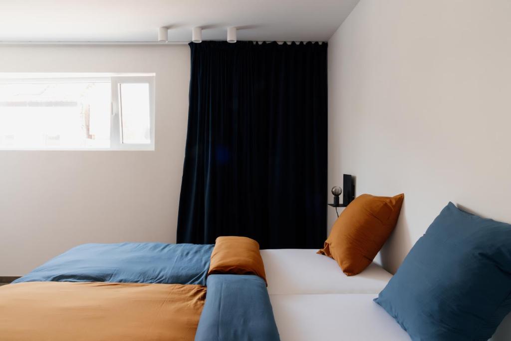 阿尔斯特Befour Vakantiewoning的一间卧室配有蓝色和橙色枕头的床