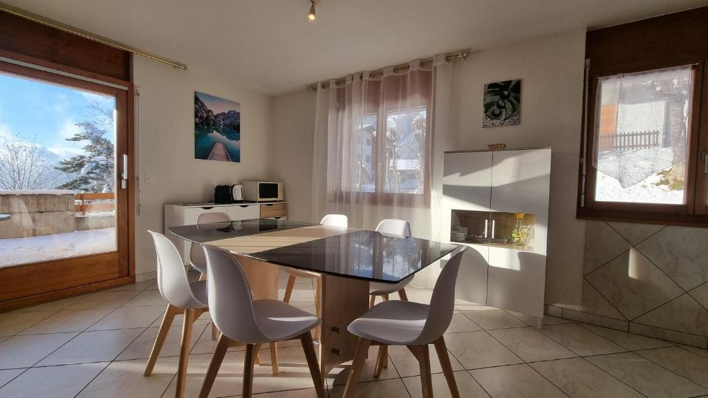 奥瓦伦纳茨Le Cormier - Appartement 6 personnes的厨房配有餐桌和白色椅子