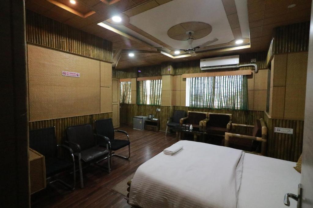 阿加尔塔拉Hotel Himalaya的一间设有床和椅子的房间和一间候机室
