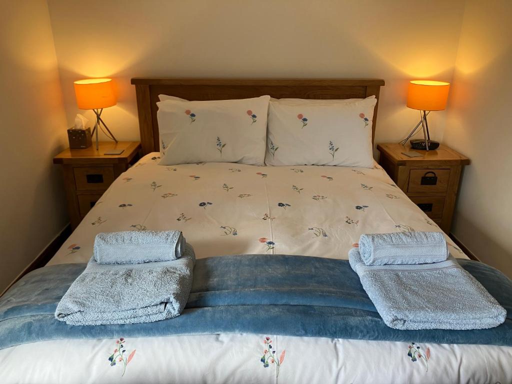 BuckdenThe Dale at Greystones - Luxurious annexe with stunning view的一间卧室配有一张床,上面有两条毛巾