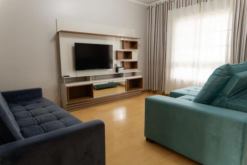 本图贡萨尔维斯Casa para 6 pessoas的客厅配有2张蓝色沙发和1台电视
