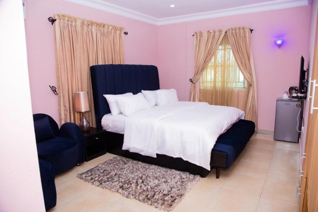 AraromiVelvetRose Cottage的一间卧室配有一张大床和一张蓝色椅子