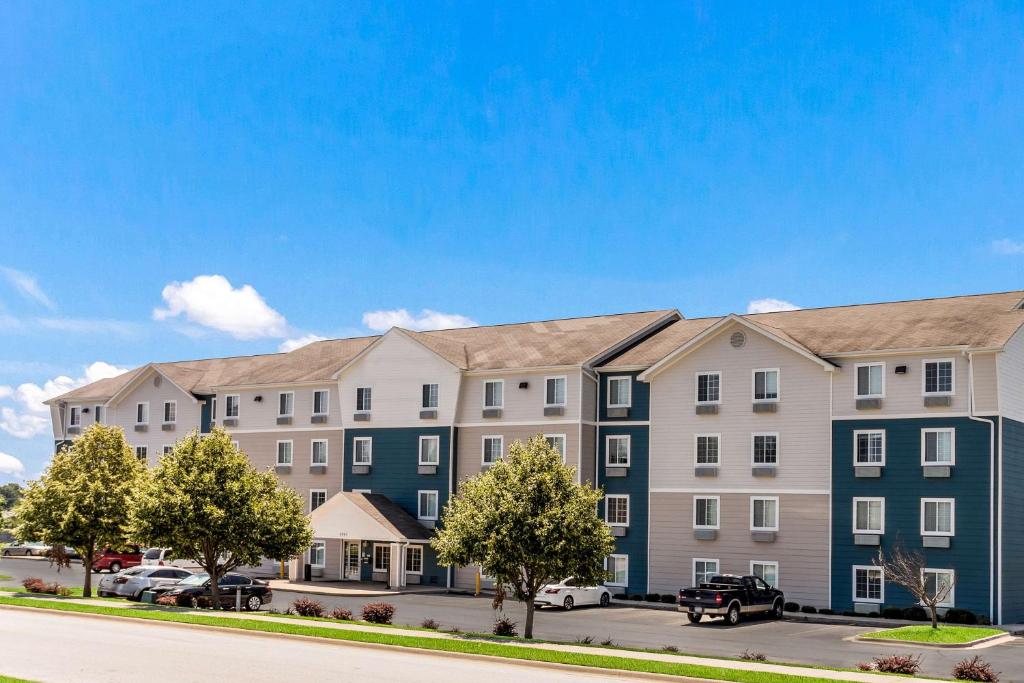 迈尔斯堡Extended Stay America Select Suites - Fort Myers的把汽车停在公寓大楼外的 ⁇ 染