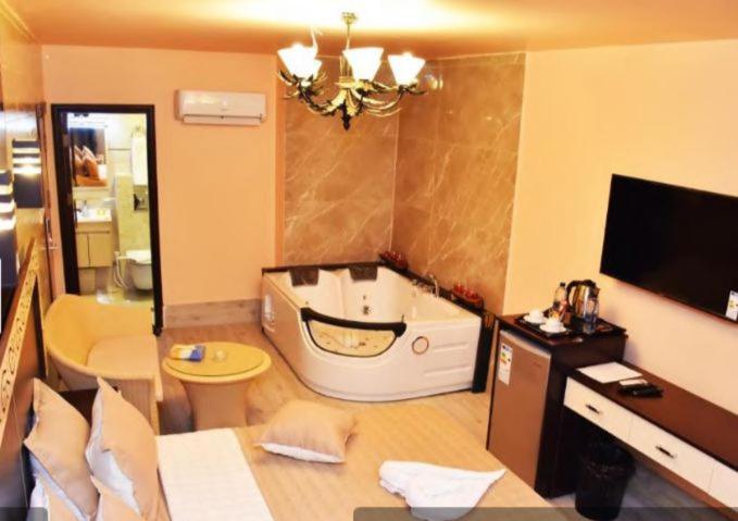 亚喀巴alnaher alkhaled boutiqu的带浴缸和卫生间的浴室以及电视。
