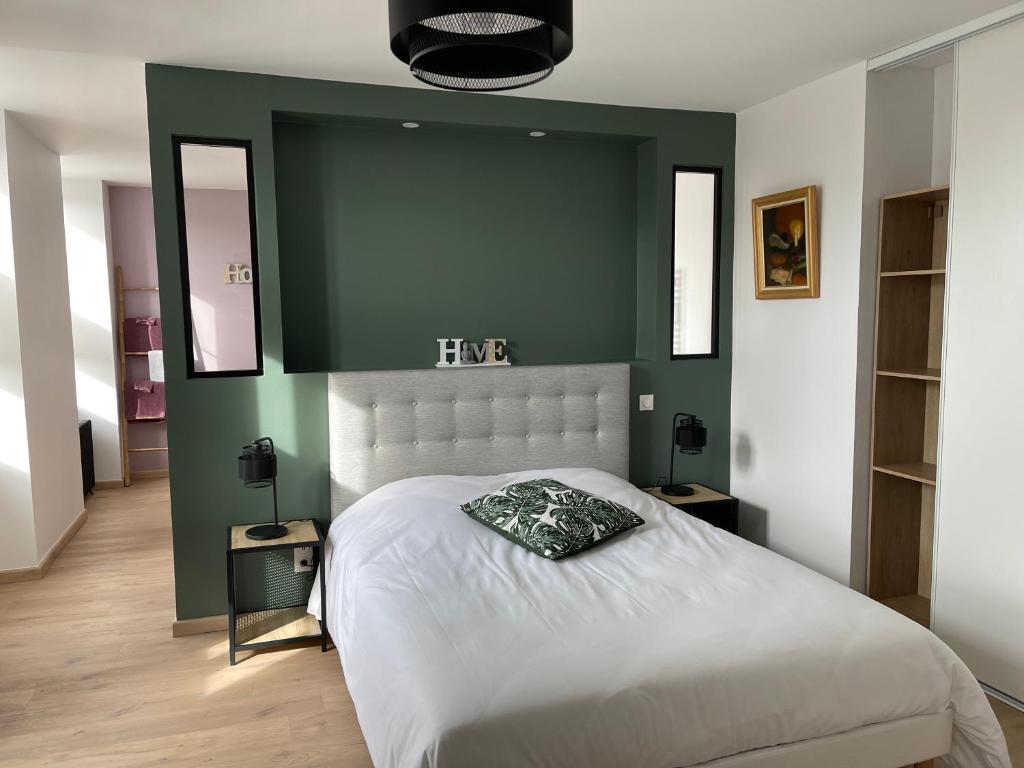 AudervilleLa petite Irlande的一间卧室配有一张白色的床和绿色的墙壁