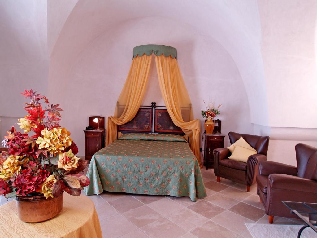 奥斯图尼玛色里阿图托萨酒店的一间卧室配有一张带天蓬的床