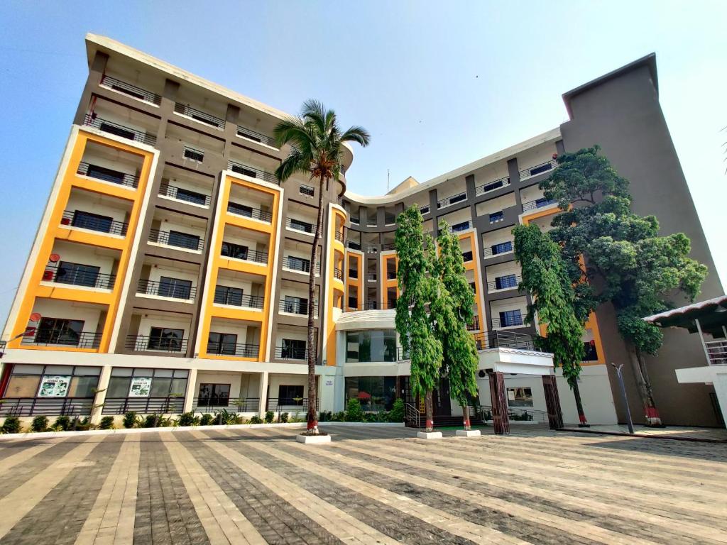 达曼Golden Chariot Hotel Daman的一座棕榈树环绕的大建筑