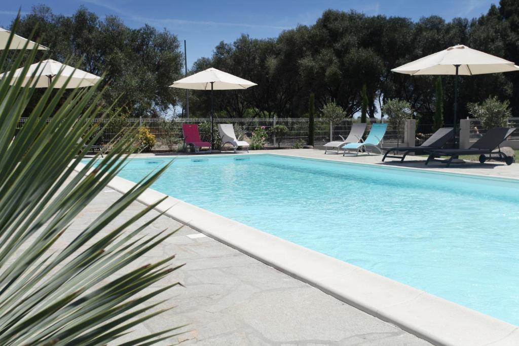 文蒂塞里珠母贝酒店的一个带椅子和遮阳伞的游泳池