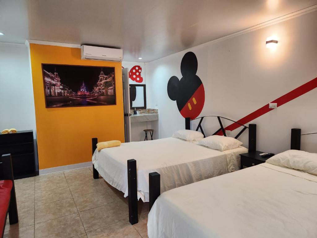 科马亚瓜Wally World Inn的一间设有两张床的客房,墙上挂着一幅画