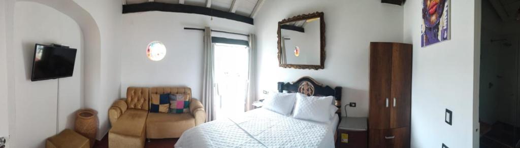 卡塔赫纳EMMA HOTEL SAN DIEGO的卧室配有白色的床和椅子