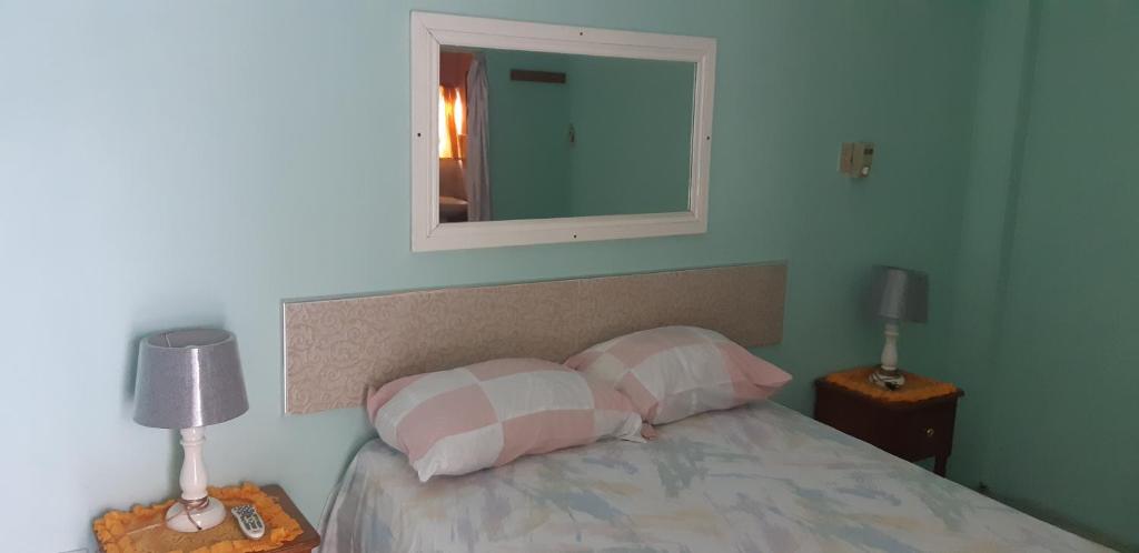 金斯敦Cliff Apartment的一间卧室配有一张带两个枕头和镜子的床