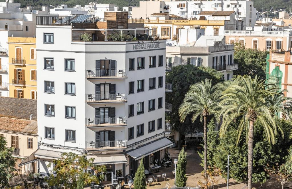 伊维萨镇Hostal Parque Ibiza的一座棕榈树城市的白色建筑