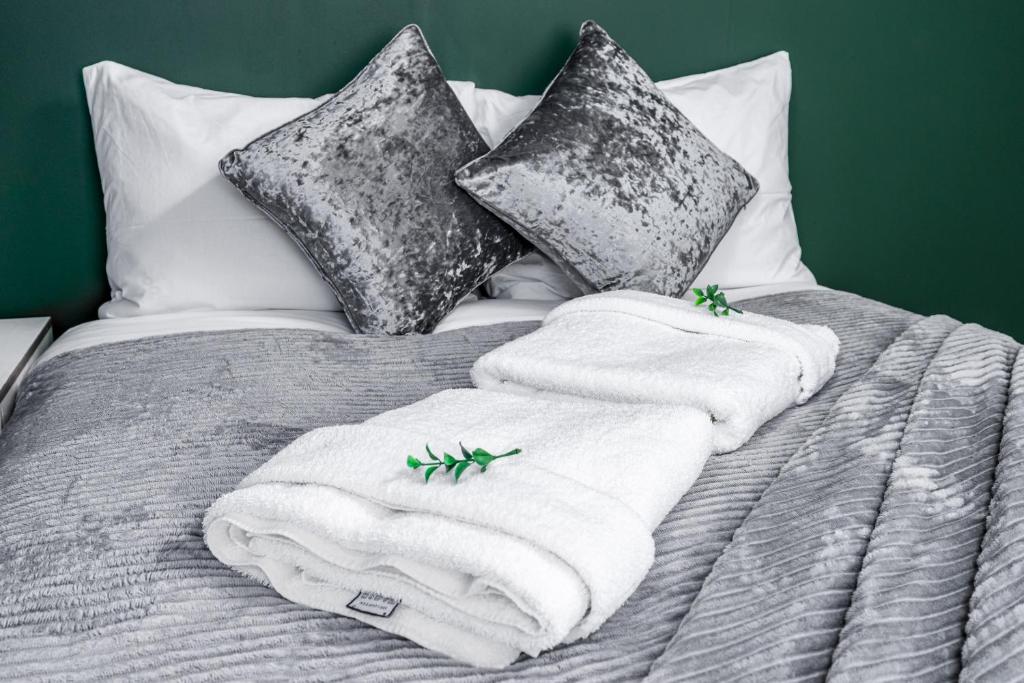 伦敦City Gate Guest House的一张带两条毛巾和枕头的床