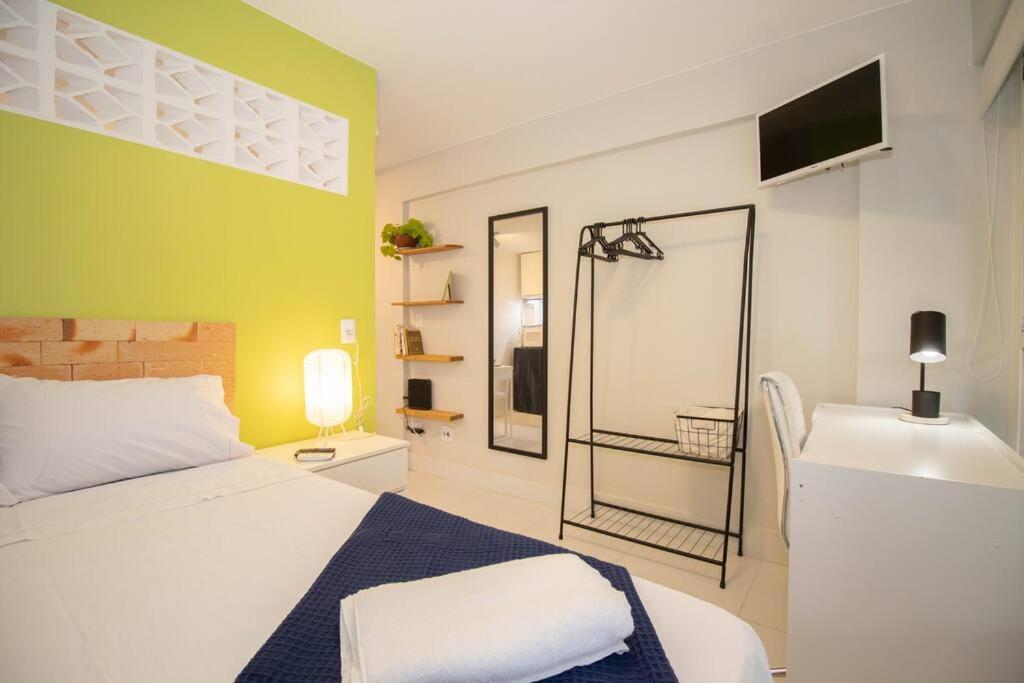 巴西利亚Studio na melhor quadra da Asa Norte的卧室配有白色的床和绿色的墙壁