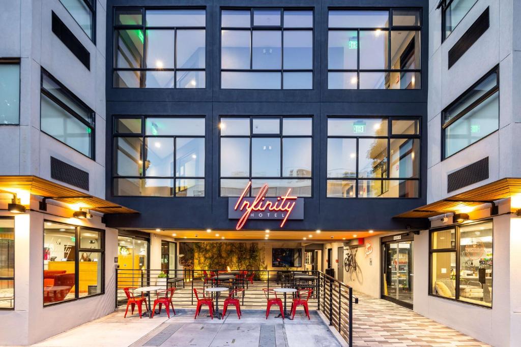 旧金山Infinity Hotel San Francisco, Tapestry Collection by Hilton的大楼前的餐厅,配有红色的桌椅