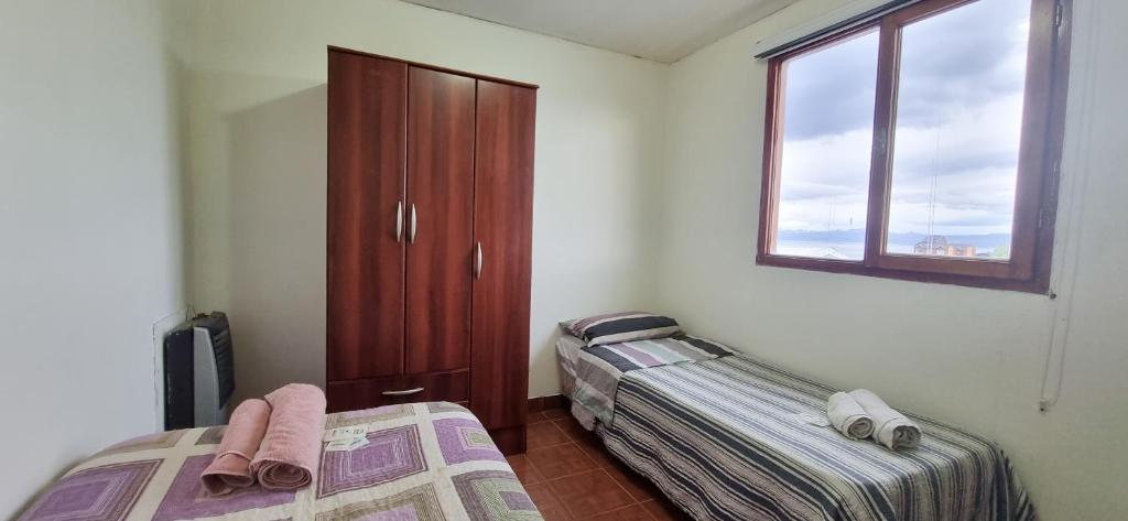 乌斯怀亚CASA COMPLETA 2 PLANTAS CON EXTRAORDINARIA VISTA AL CANAL BEAGLE CENTRICA 4pax的一间卧室设有两张床和窗户。