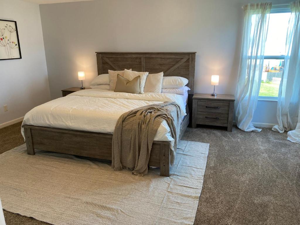 GroveportNewley Remodel 5 - Bedroom Home Sleeps 16的一间卧室配有一张大床、两个床头柜和一扇窗户。