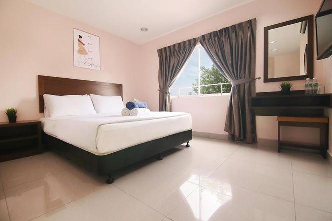 Batang BerjuntaiSun Inns Hotel Bestari Jaya的一间卧室设有一张大床和一个窗户。