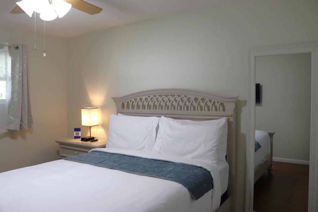莱克兰Hidden Sapphire-Apartment with Kitchen and Laundry的一间卧室配有带白色床单和枕头的床。