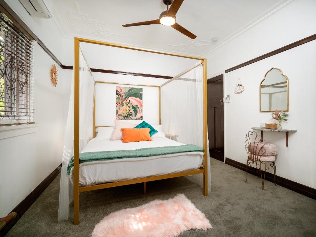 布里斯班Anville Court的一间卧室配有带橙色枕头的天蓬床