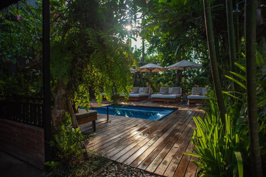 坎古Pangkung Sari Bed and Breakfast的后院设有木甲板和游泳池