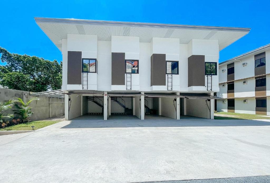 奥隆阿波RedDoorz @ Washington Guest House Olongapo的停车场上设有窗户的大型白色建筑