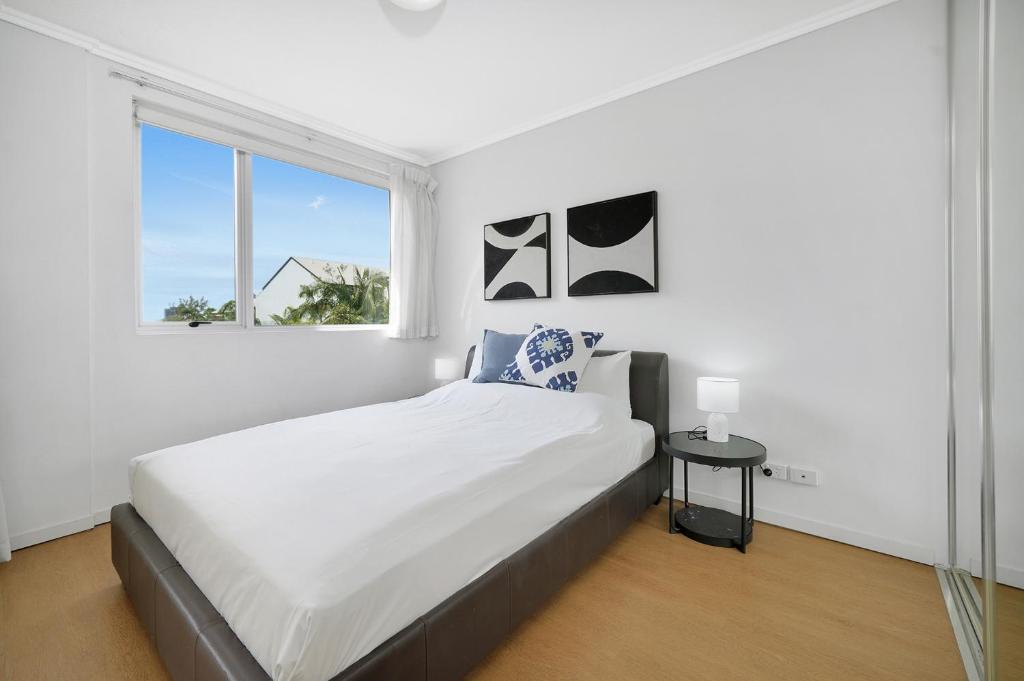 布里斯班布里斯班三部曲公寓式酒店的白色的卧室设有一张大床和一个窗户