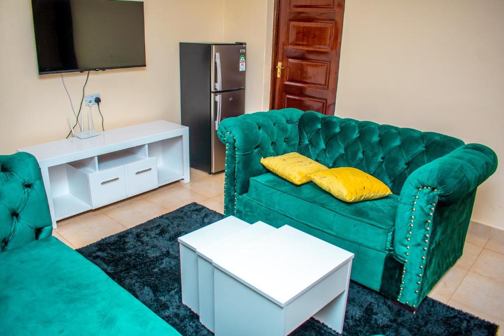 KisiiCozy apartment kisii的客厅配有绿色沙发和电视