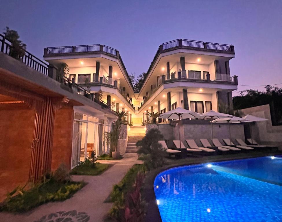 ToyapakehGrand Yuna Hotel Nusa Penida的一座大房子,前面设有一个游泳池