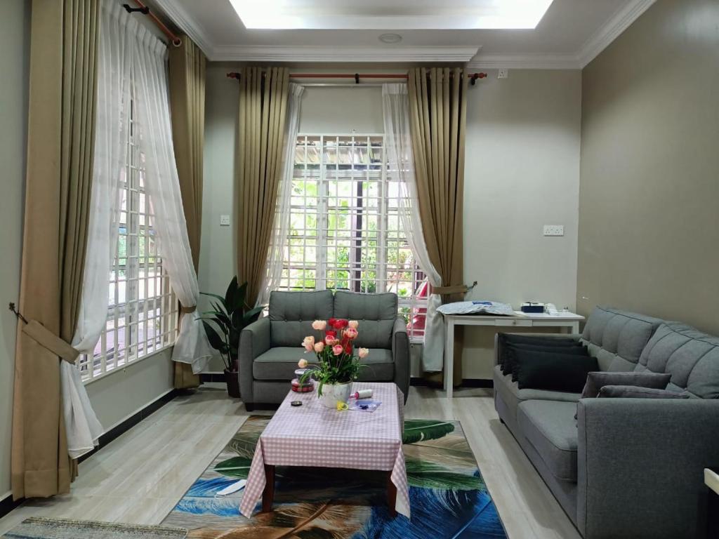 瓜拉丁加奴Sya Al-Yahya Homestay的客厅配有沙发和鲜花桌