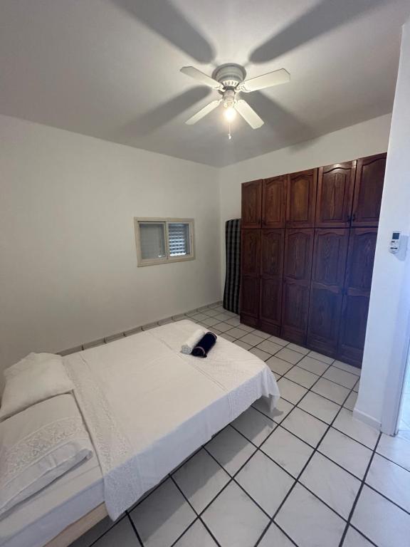 提比里亚Casa de Galilee的一间卧室配有一张床和吊扇