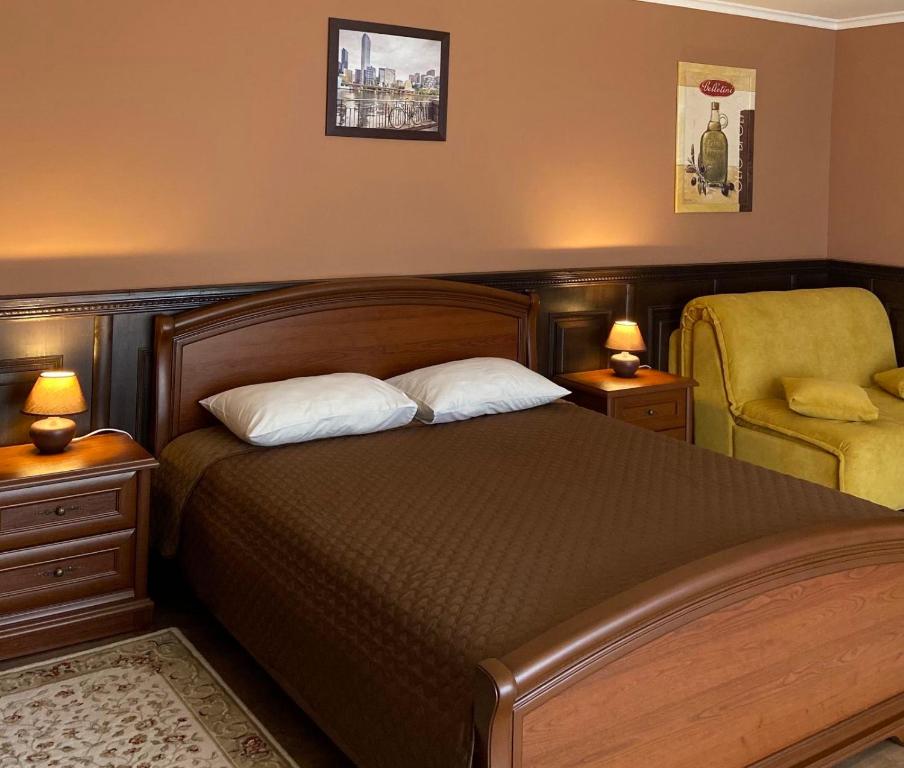 比尔戈罗德-德尼斯特罗夫西基ЭкоДом的一间卧室配有一张床、一把椅子和两盏灯。