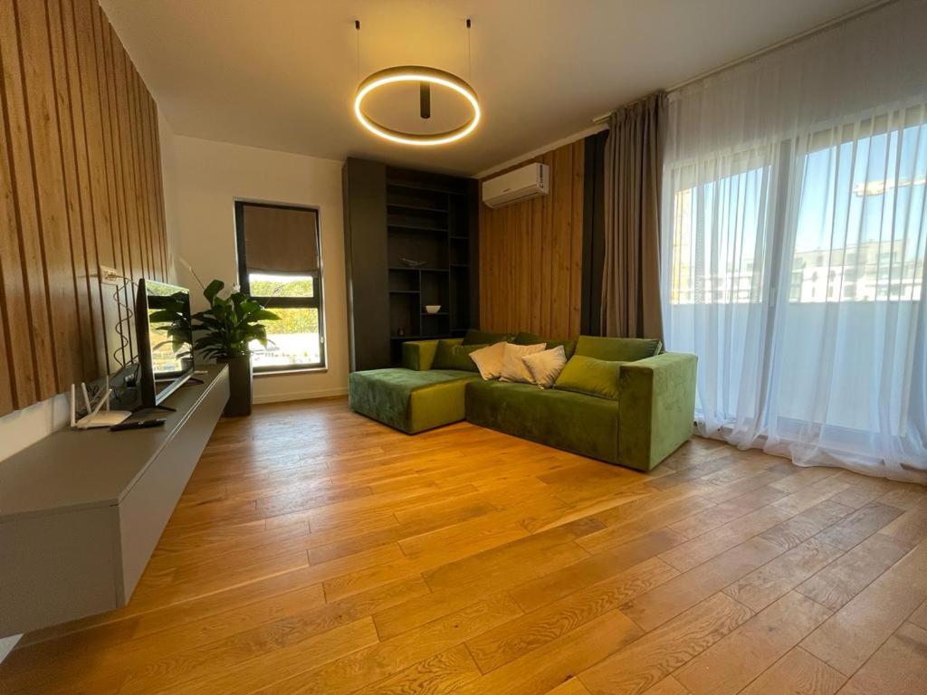 布加勒斯特UpNorth Home的客厅配有绿色沙发和电视