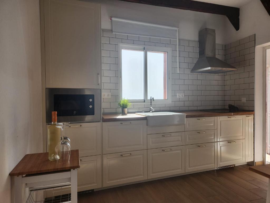 阿列塔HOUSE SAL Y MAR的厨房配有白色橱柜、水槽和窗户。