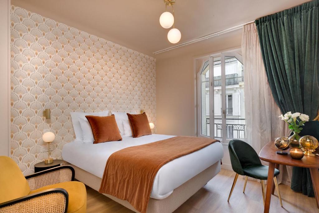 巴黎Artemisia Montmartre的配有一张床、一张书桌和一扇窗户的酒店客房