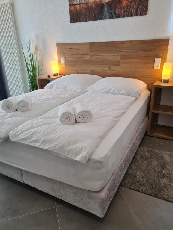 阿伦WellandHome Aalen - 6 Rooms的卧室内的两张床,配有白色床单和枕头