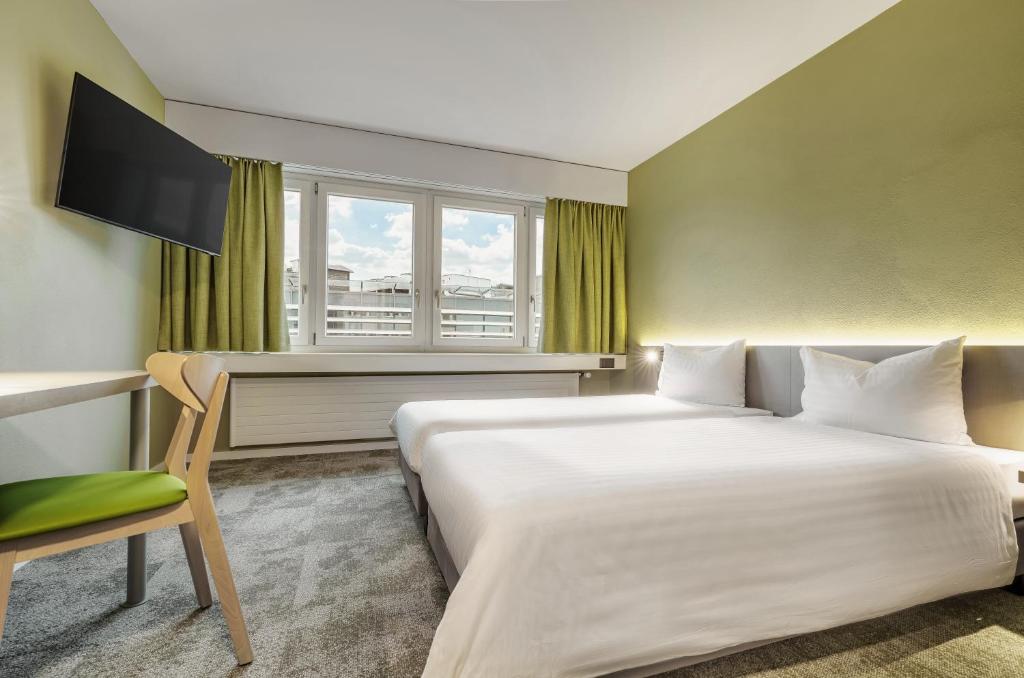 维尔flexymotel Wil的配有一张床、一张书桌和一扇窗户的酒店客房