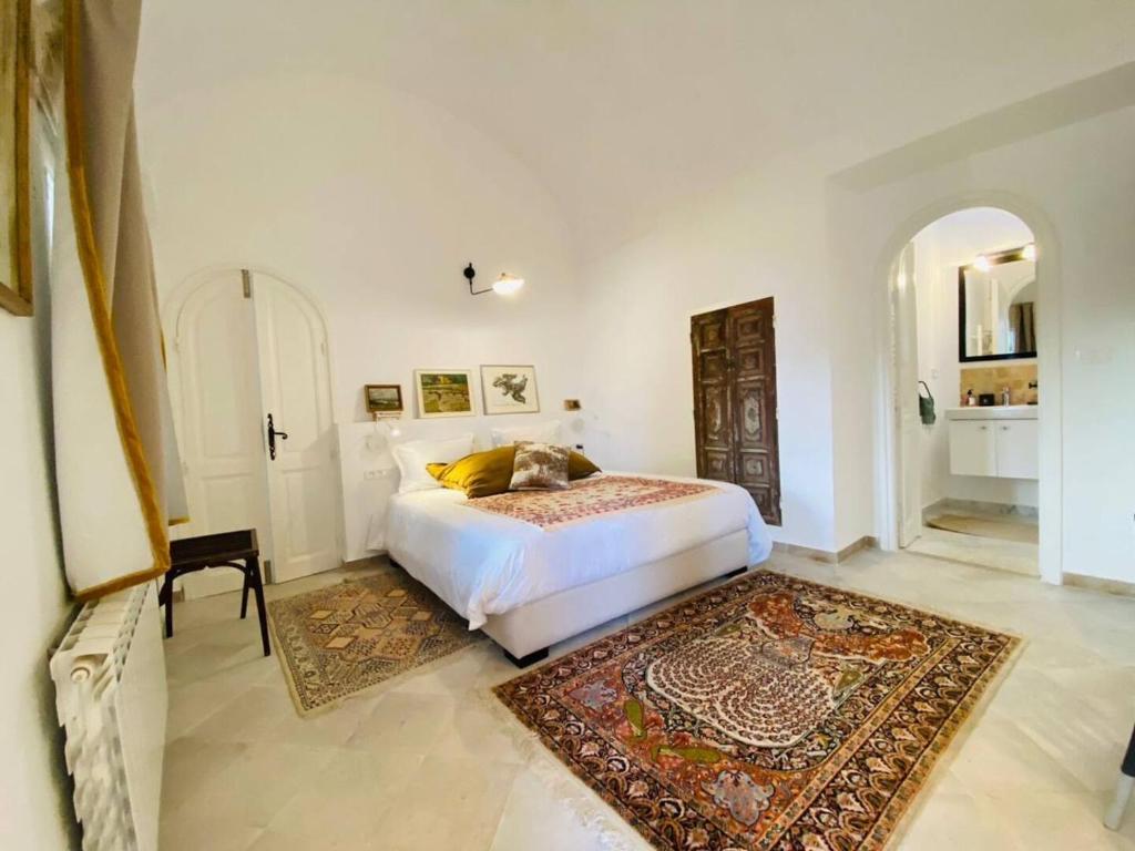 西迪·布·赛义德Lella Zohra, Studio avec Piscine à Sidi Bou Said的卧室配有白色的床和地毯。