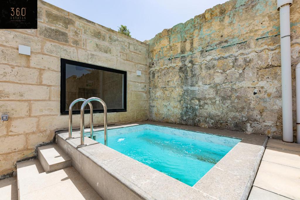姆迪纳Historical Mdina Gem, Lux HOME with Rooftop Pool by 360 Estates的砖墙内的大型游泳池